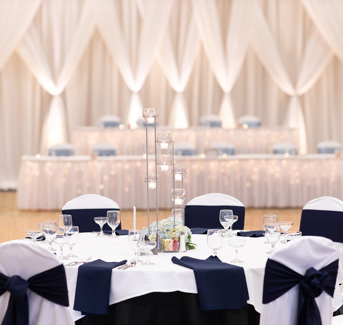 wedding reception table with dark linens and tall candle holder